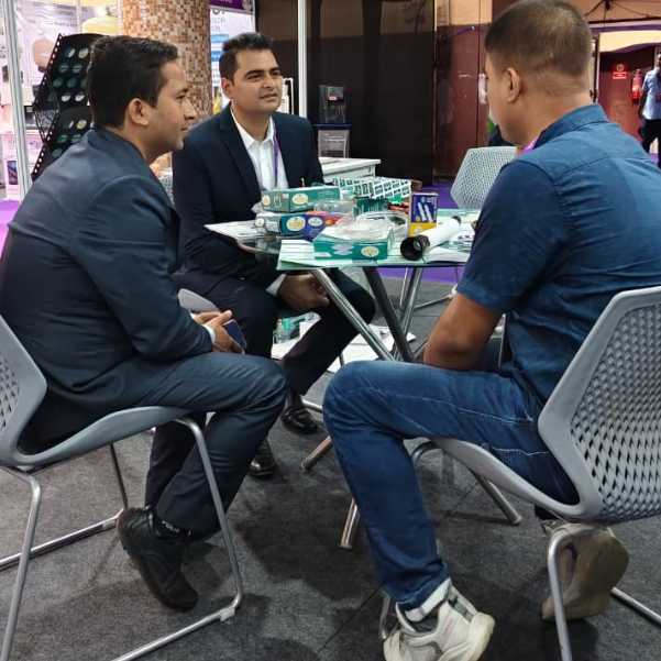 Petro Industech representatives with visitor at trade exhibition showcasing nylon sleeve and bathroom accessories products